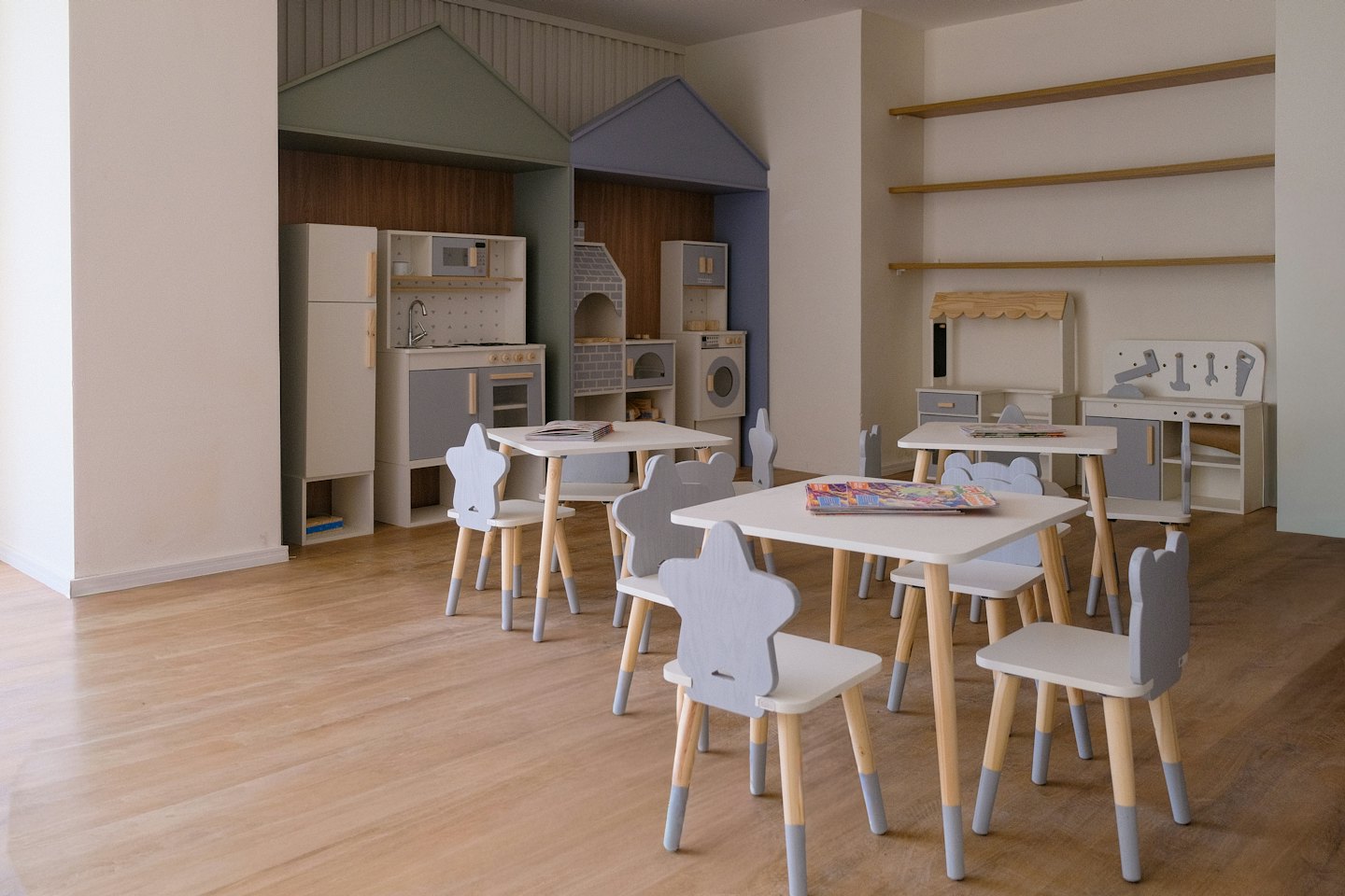 Helles Spielzimmer mit Stern- und Bärenstühlen sowie Spielküchen.